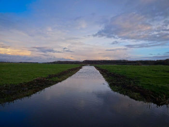 Scenic view of agricultural field against sky during sunset