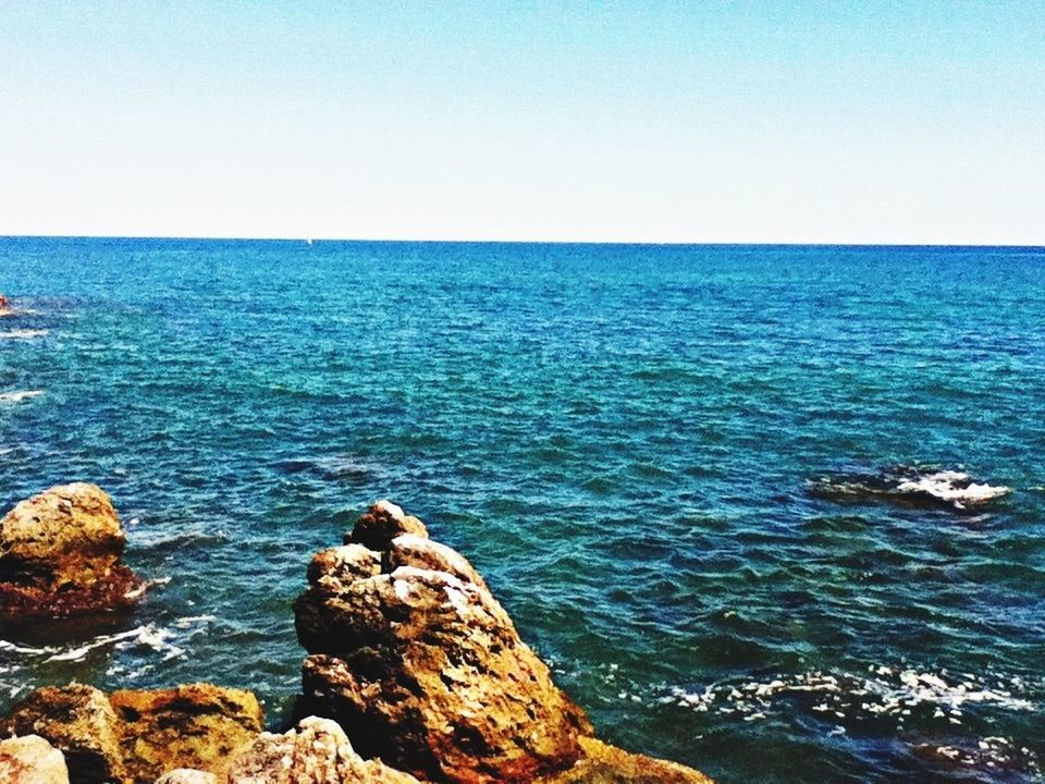 sea, water, horizon over water, clear sky, blue, rock - object, scenics, beauty in nature, tranquil scene, tranquility, copy space, nature, rock, rock formation, idyllic, rippled, seascape, sky, day, outdoors