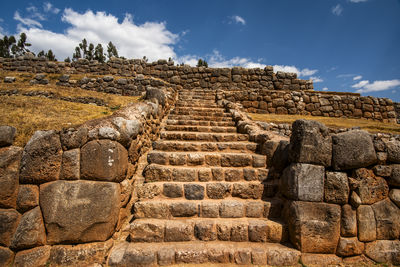 Low angle view of stone wall against sky