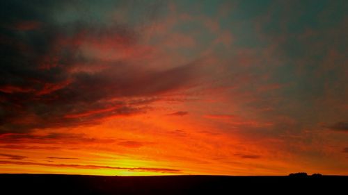 Silhouette of landscape against cloudy sky