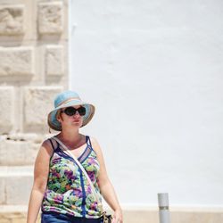 Young woman looking away while standing against wall
