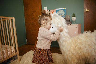 Toddler girl hugging her stuffed animal happily