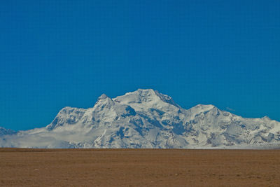 Scenic view of snowcapped mountains against clear blue sky