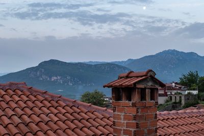 Houses on mountain against sky