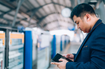 Side view of man using mobile phone