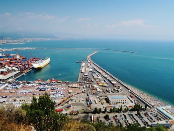 High angle view of city by sea against sky