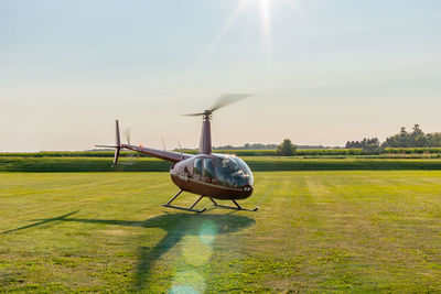 Airplane on field against sky on sunny day