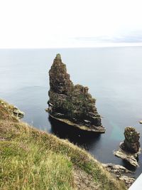 Rock formation on beach against sky