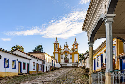 A quiet historic street in the city of tiradentes with colonial houses and a baroque church