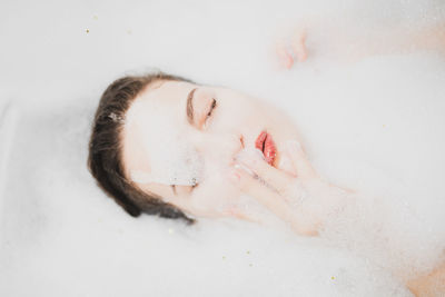 Close-up of young woman with eyes closed in bathroom