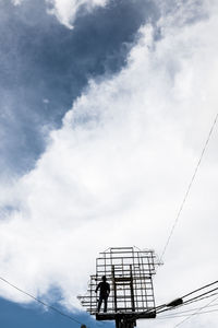 Low angle view of silhouette people standing against sky