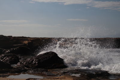 Water splashing in sea against sky