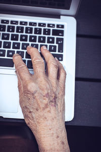 Cropped hand using laptop