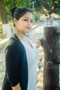 Side view of young woman looking at camera