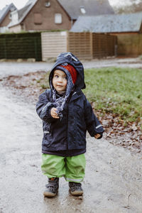 Portrait of cute boy standing on road