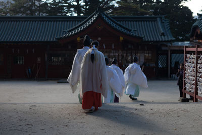 Rear view of people walking at temple