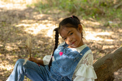 Portrait of cute girl sitting on land