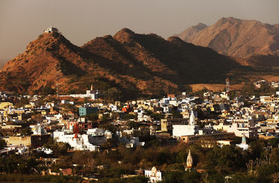 Residential district and mountains against clear sky