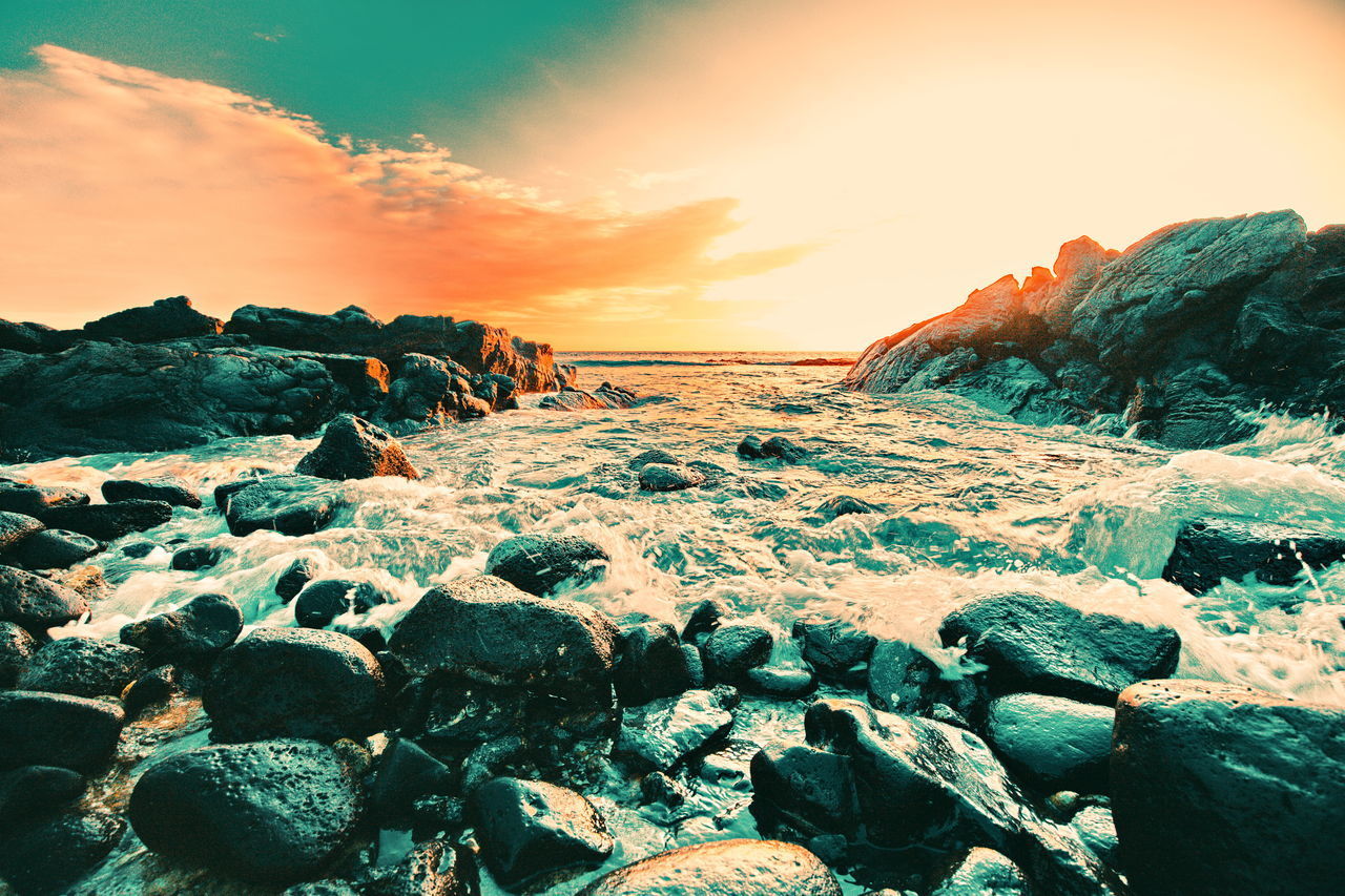 ROCKS ON BEACH AGAINST SKY DURING SUNSET