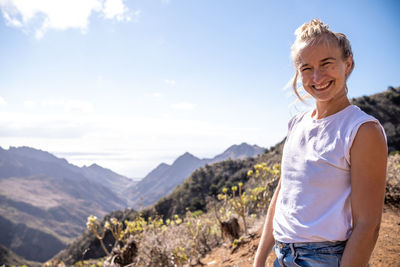 Portrait of a blonde girl smiling at sunset in the mountain