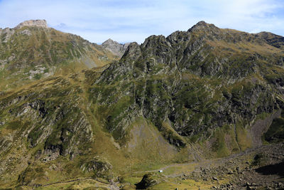 Scenic view of land and mountains against sky