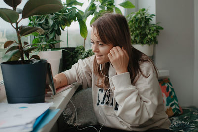 A young pretty woman in headphones communicates via video chat with mobile phone. high quality photo