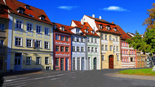 Buildings by street against sky in city