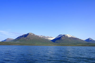 Scenic view of snowcapped mountains against blue sky