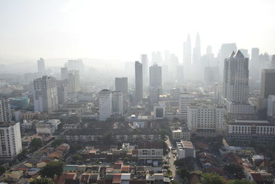 Aerial view of buildings in city against sky