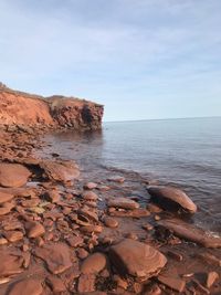 Scenic view of rocks on beach against sky