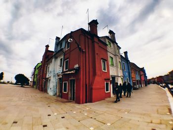 People walking on street amidst buildings in city