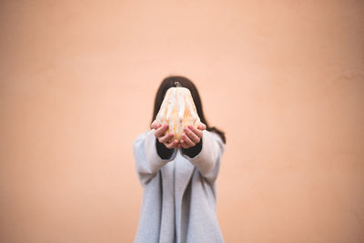 Midsection of woman standing against wall