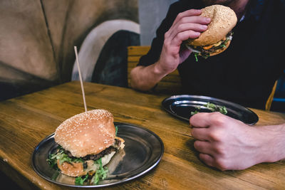 Midsection of man holding ice cream on table