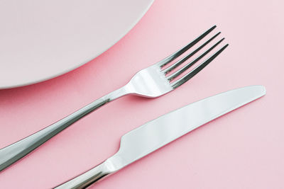 High angle view of fork and spoon on white background