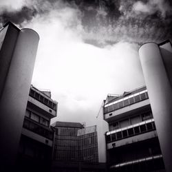 Low angle view of modern building against cloudy sky