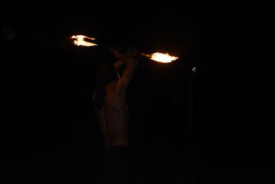 Midsection of man holding sparkler at night