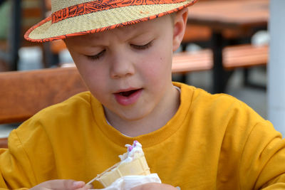 Close up image of boy hand holding fresh waffle cone with vanilla