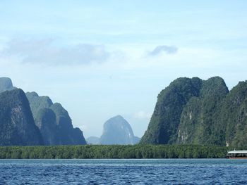 Scenic view of sea and mountains against sky