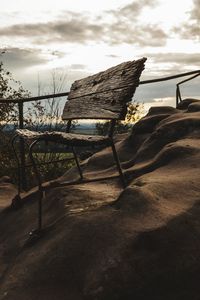 Chair on shore against sky