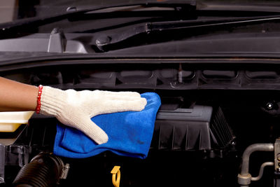 Cloth worker cleaning the car engine room