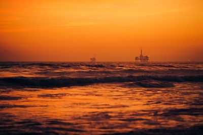 Scenic view of sea against orange sky