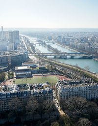 High angle view of bridge over river by buildings in city against sky