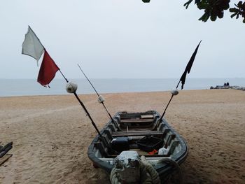 Flag on beach against sky