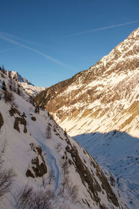 Scenic view of snowcapped mountains against blue sky