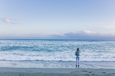 Rear view of woman looking at sea against sky