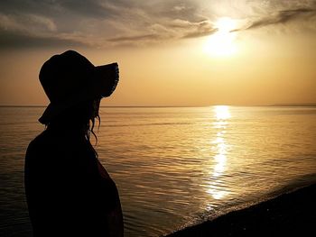 Silhouette woman at beach during sunset