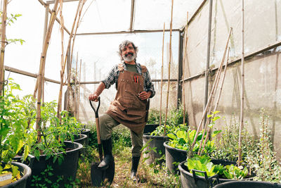 Portrait of young man working in greenhouse