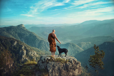 Side view of woman standing on mountain