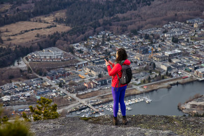 Rear view of woman photographing cityscape