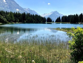 Scenic view of lake by mountains against sky